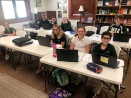 students sitting at their desks with their computers