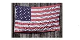 US Flag displayed on the side of a an aged barn.