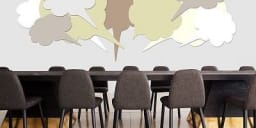 Conference room tables with empty chairs around it and multiple idea bubbles above the table