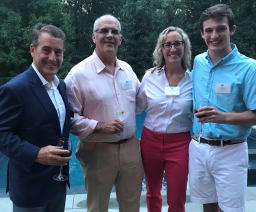 A student with parents and faculty at a reception