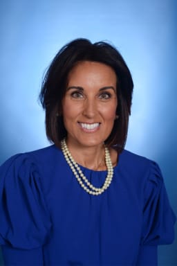 photo of woman with brown hair in blue dress