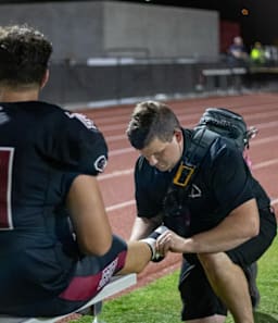 Ian Jeffer treating a football player at Desert Ridge High