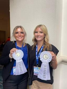 two TCHS TAFE students holding white ribbons