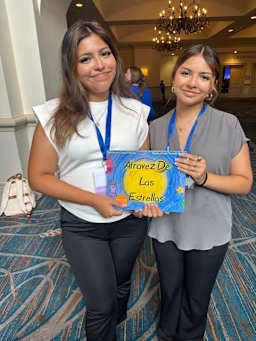 Two TCHS TAFE students holding spanish children's book