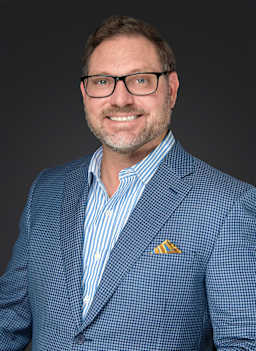 Image of our board member Mr. Clint Harrington wearing a blue suit