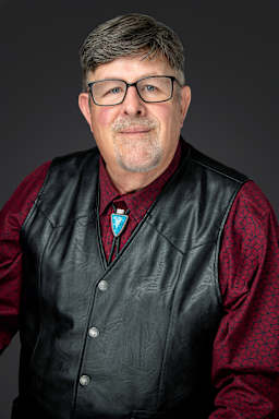 our board member Mr. Charles Wesner wearing a black vest and a red shirt