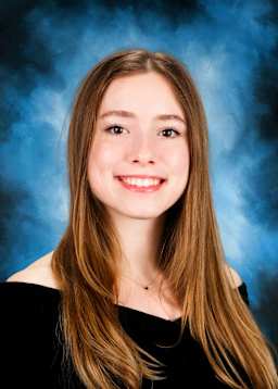 The image shows a smiling young woman with long brown hair against a blue background.