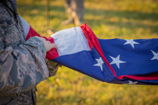 Baseball fan stands in rain to hold umbrella over JROTC member