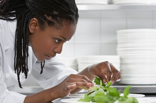 Student adjusting the garnish on a salad plate