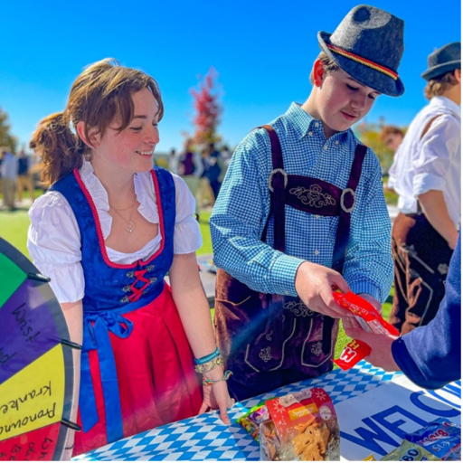 A girl and boy in traditional German clothing smiling