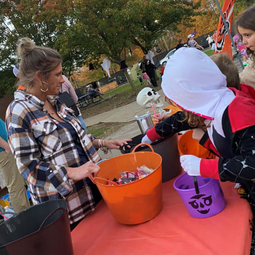 PTO president passing out candy at Trunk or Treat event