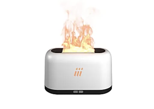 A white and black device resembling a toaster emits realistic orange and yellow flames from the top. The scene appears humorous and surprising.