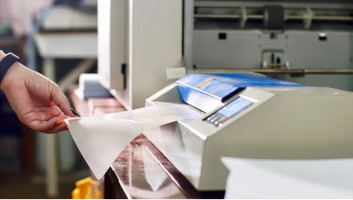 hand inserting paper into laminator