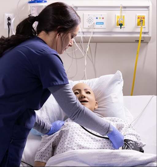 Student taking blood pressure in simulation
