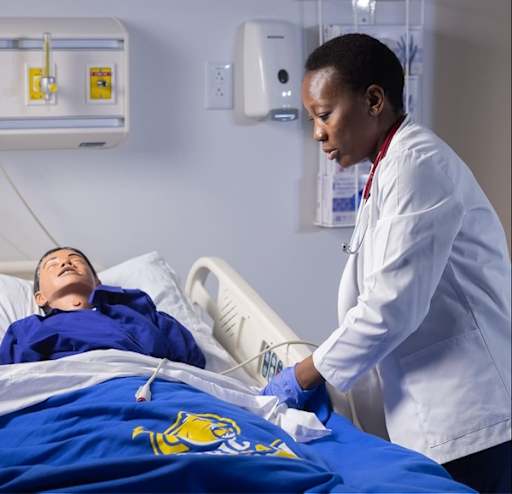 Student adjusting a hospital bed in simulation