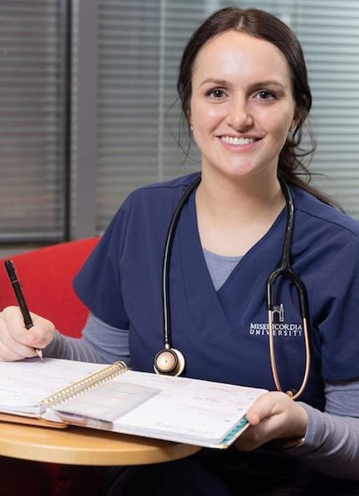 Student smiling while holding a planner