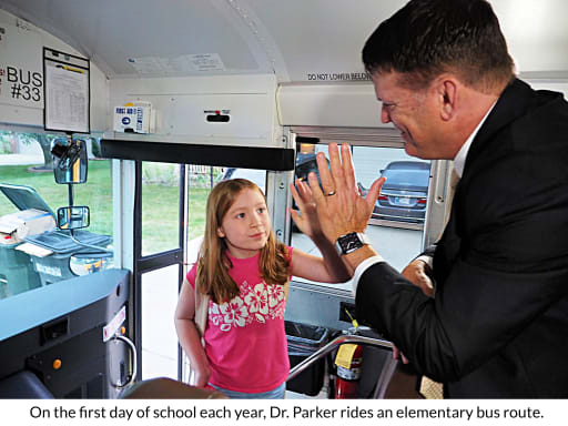 Dr. Parker High-Fiving a Student Entering the Bus