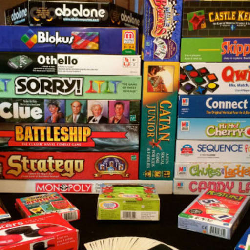 stack of board games like monopoly and clue