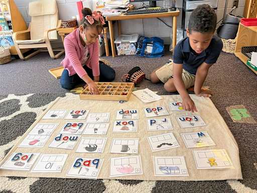 Two young students working on a phonics sorting activity