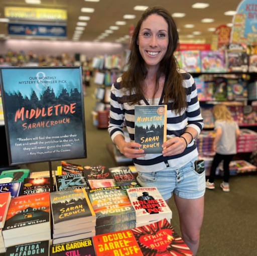 Sarah Crouch, author, holding her book titled Middletide.