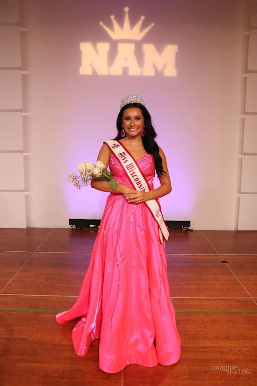 Leia Rios on stage in pink gown with crown and sash