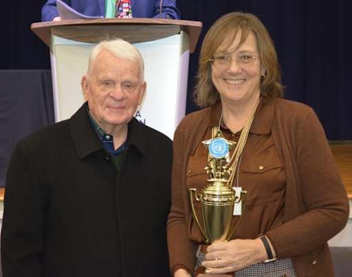 Two people standing with Model UN trophy