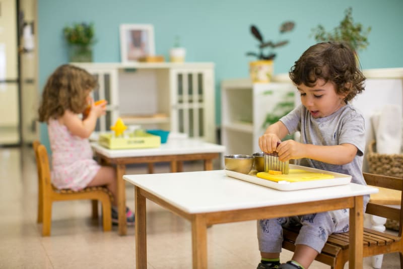 students in the young children's community serve themselves a snack