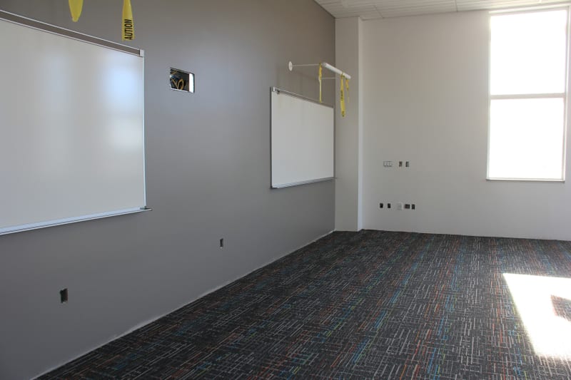 View of classroom with paint, whiteboards and carpet.