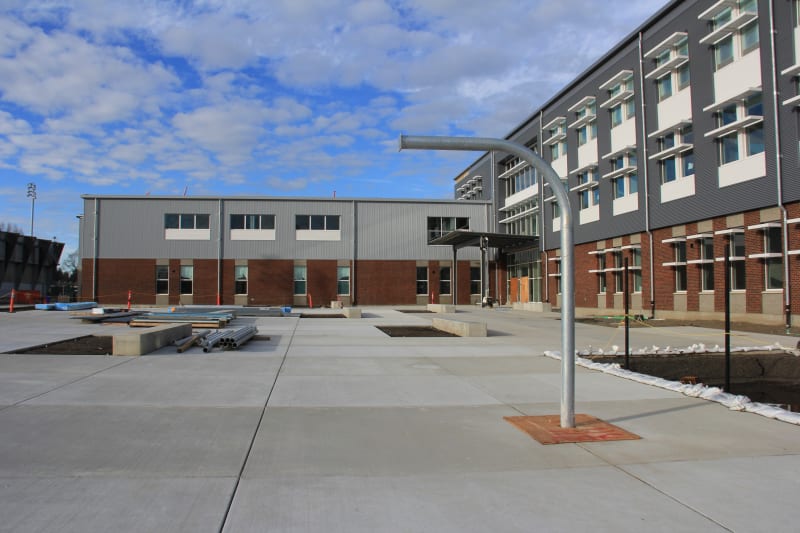 View of south courtyard with post for outdoor basketball hoop and outdoor seating.