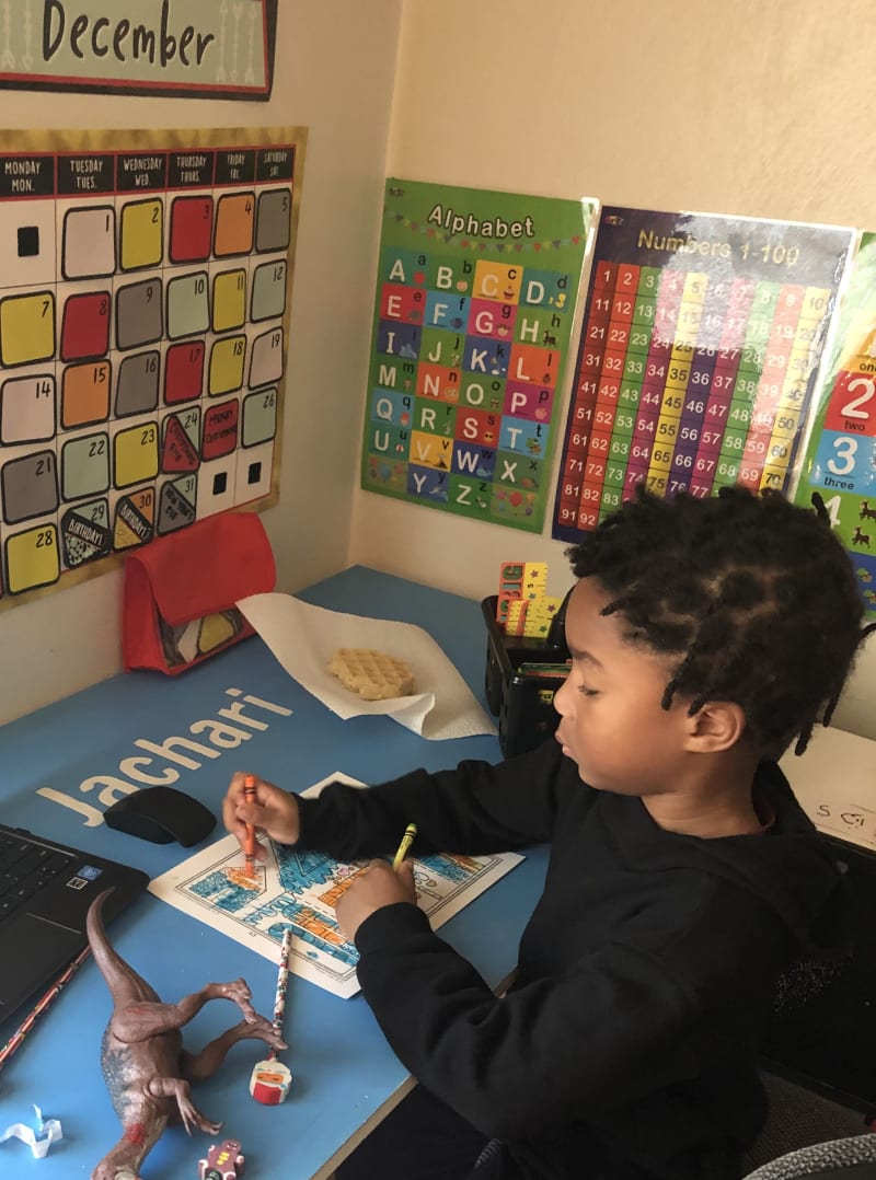 Young boy sitting at a desk virtually learning