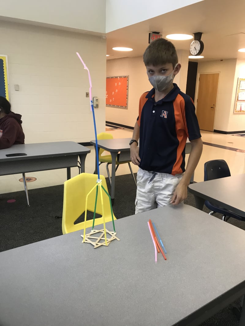 Student with a plastic straw build project