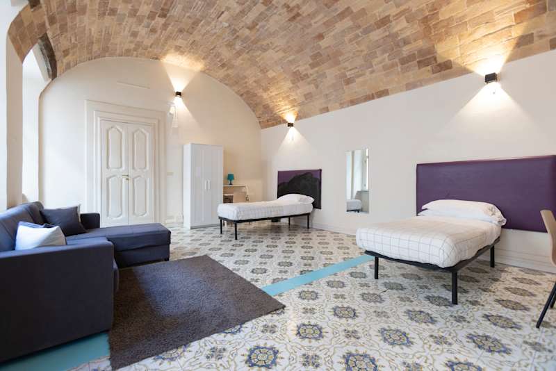A spacious double student room inside Palazzo De Giorgio