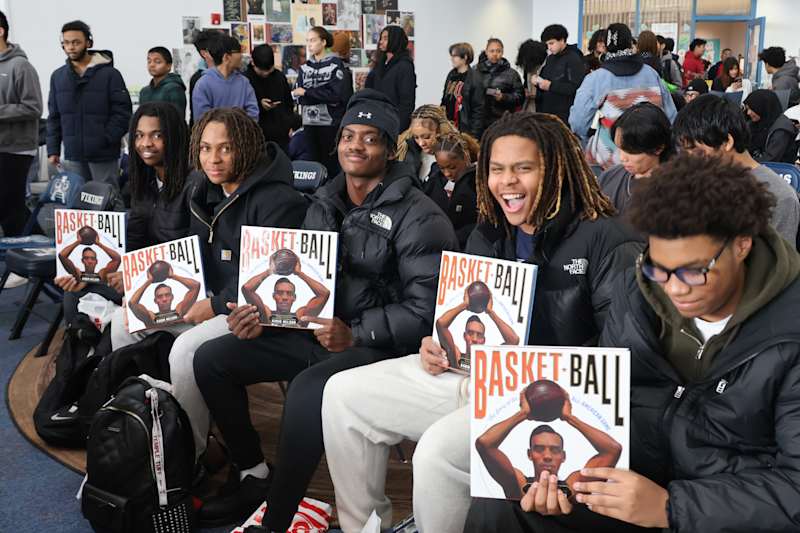 Atlantic City High School athletes show signed copies of Kadir Nelson's book about basketball.