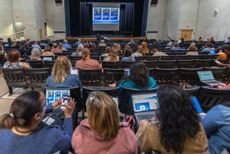 District administrators and instructional leaders attending an educational tech seminar inside an auditorium.