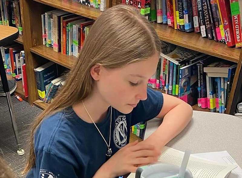 Middle school girl reading in the library