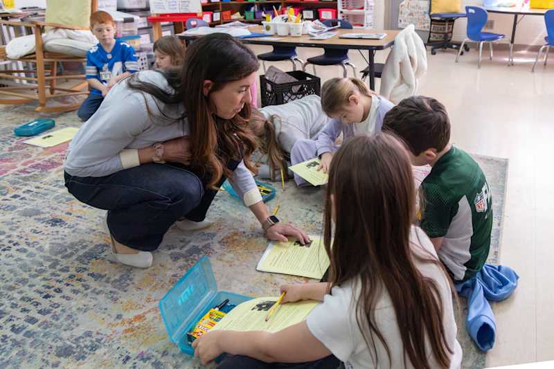 A first-grade instructor presenting custom text exercises to small student groups at Providence Spring Elementary School.