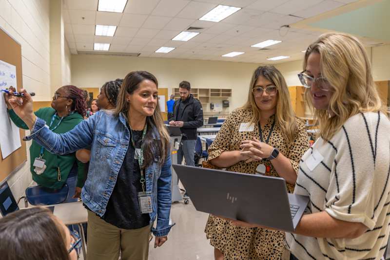Three educators working in a small team to build personalized learning paths with an approved AI utility tool.