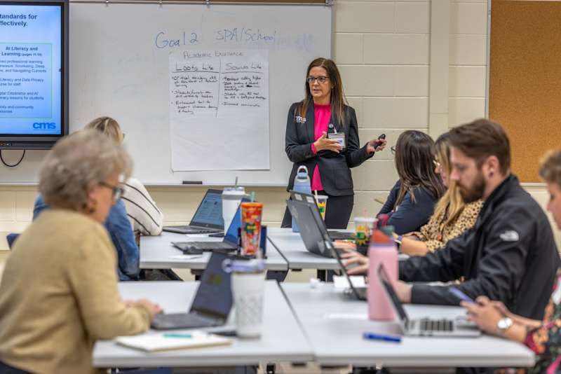 A program coordinator outlining student data privacy guidelines on a whiteboard to school-level AI Champions.