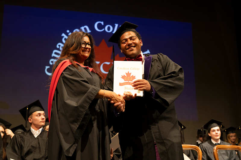 A graduate receiving congratulations and a diploma