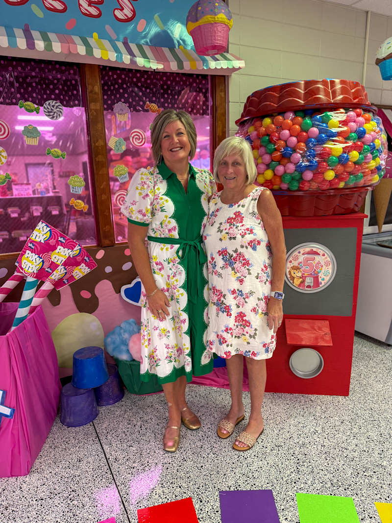 Michelle Taylor and Kim Jenkins in front of a colorful candy-themed display.