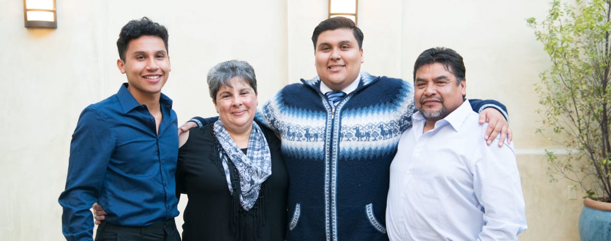 Two students standing with their parents