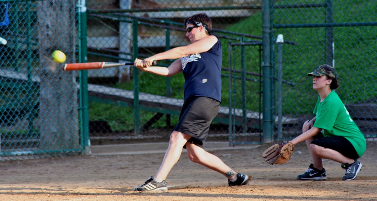 Two people playing softball at a Lakewood adult softball game.