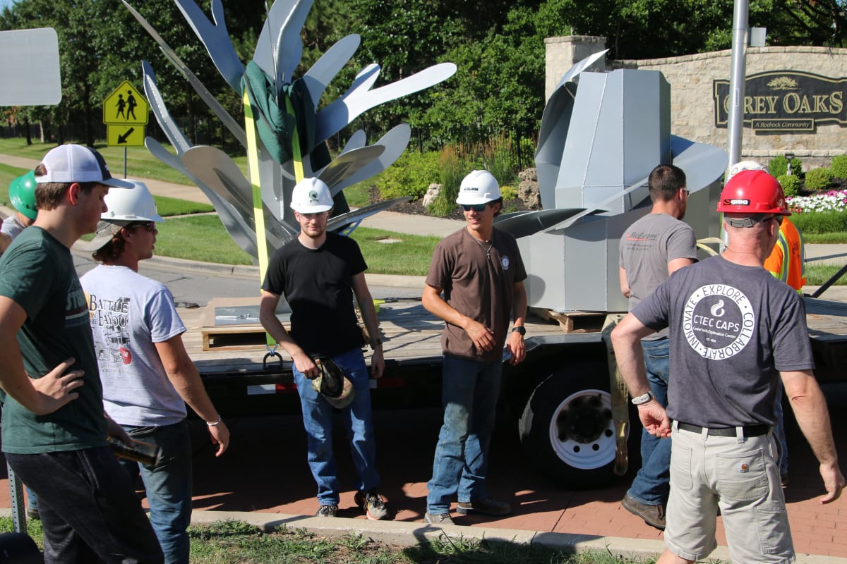 Students and teachers placing sculpture project