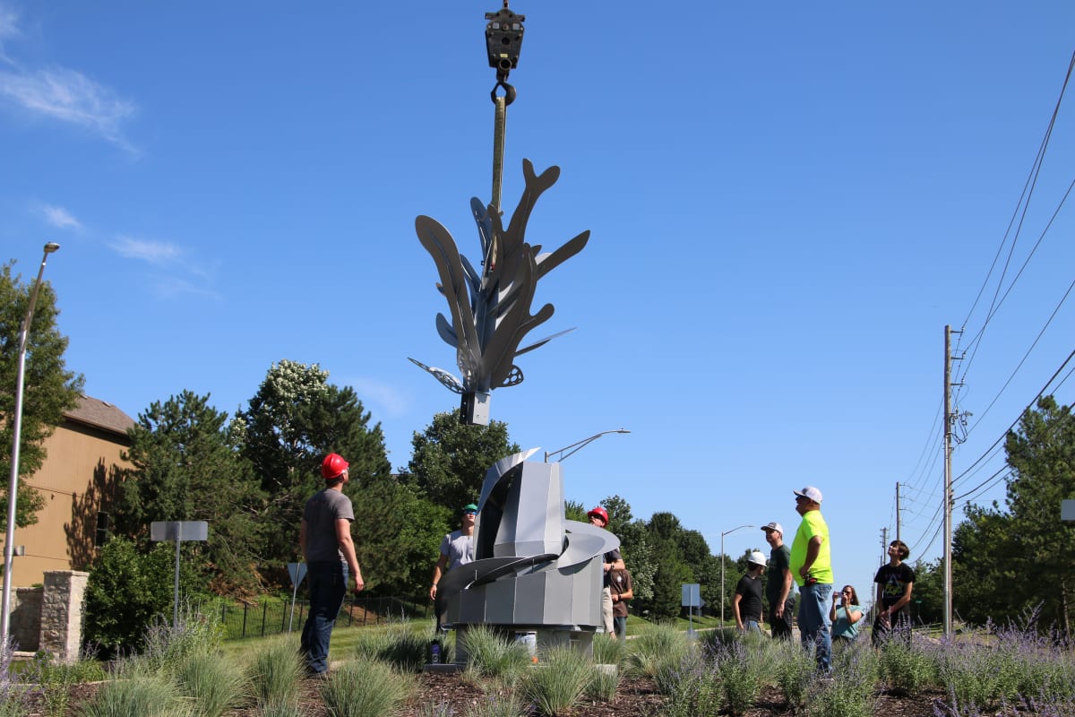 Students and teachers placing sculpture project