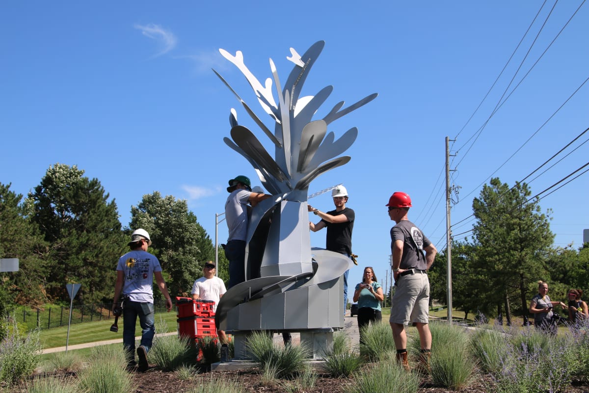 Students and teachers placing sculpture project