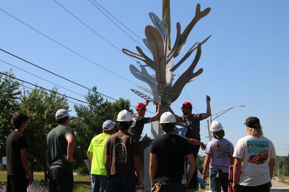 Students and teachers placing sculpture project