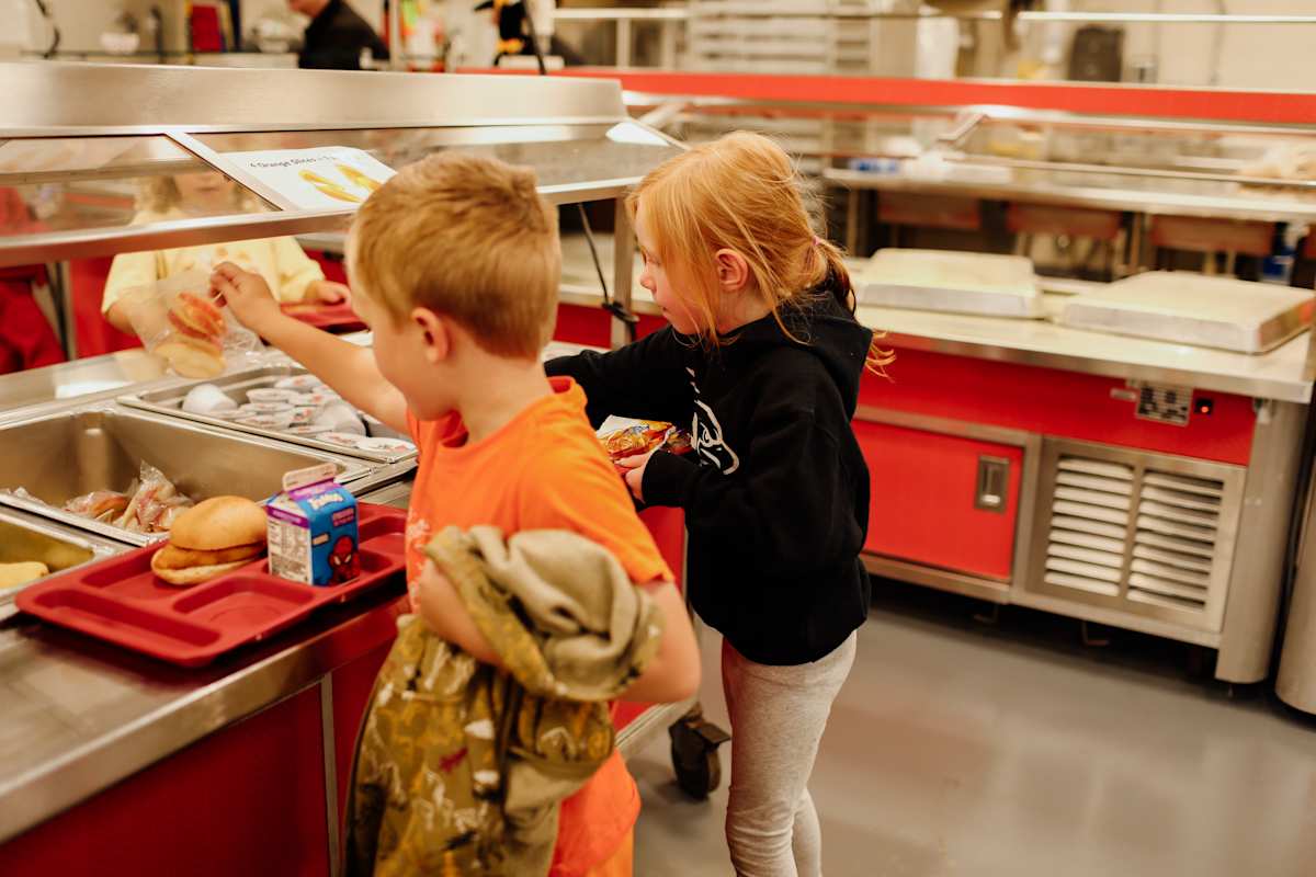 Two elementary students getting lunch.