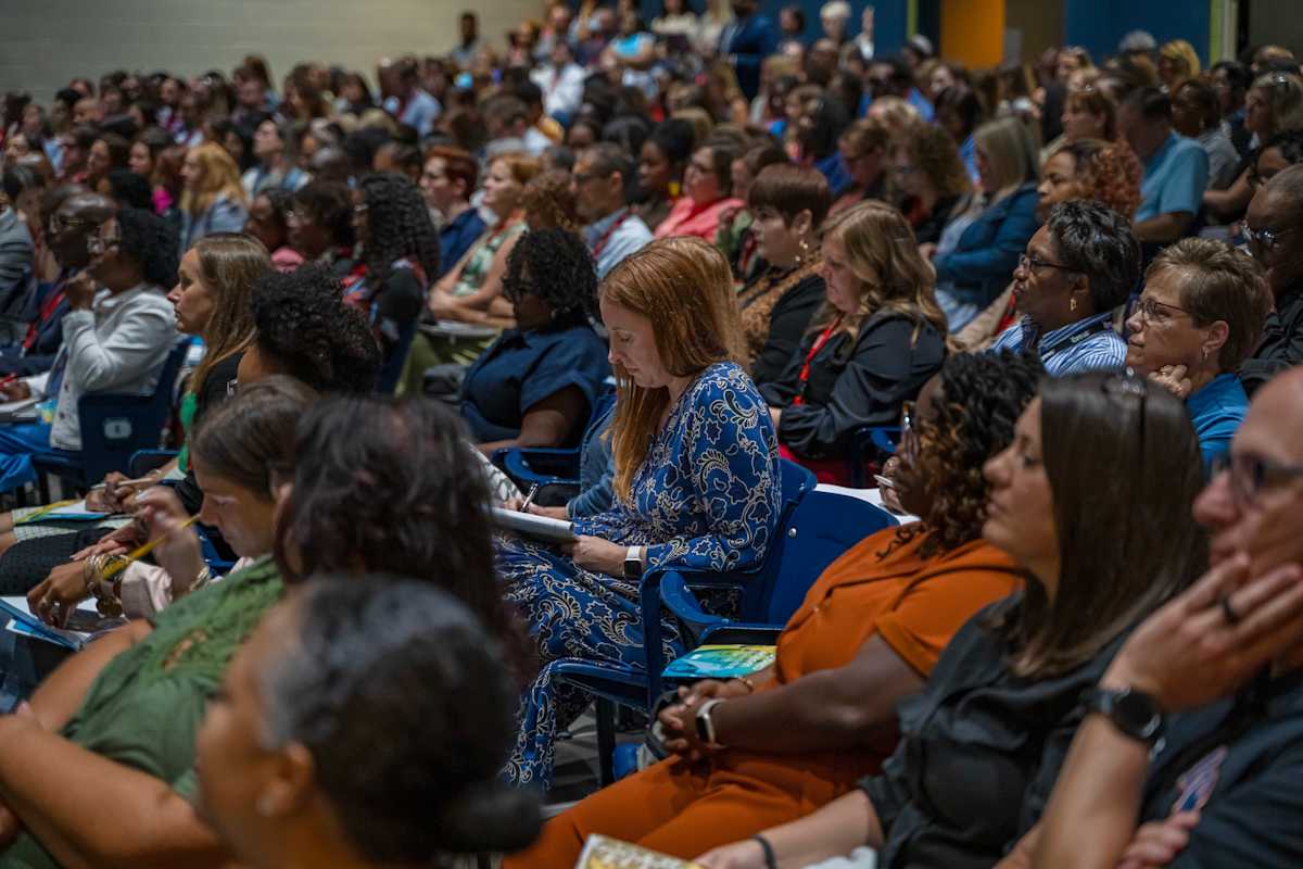Large group of staff members gathered in an auditorium for a district presentation