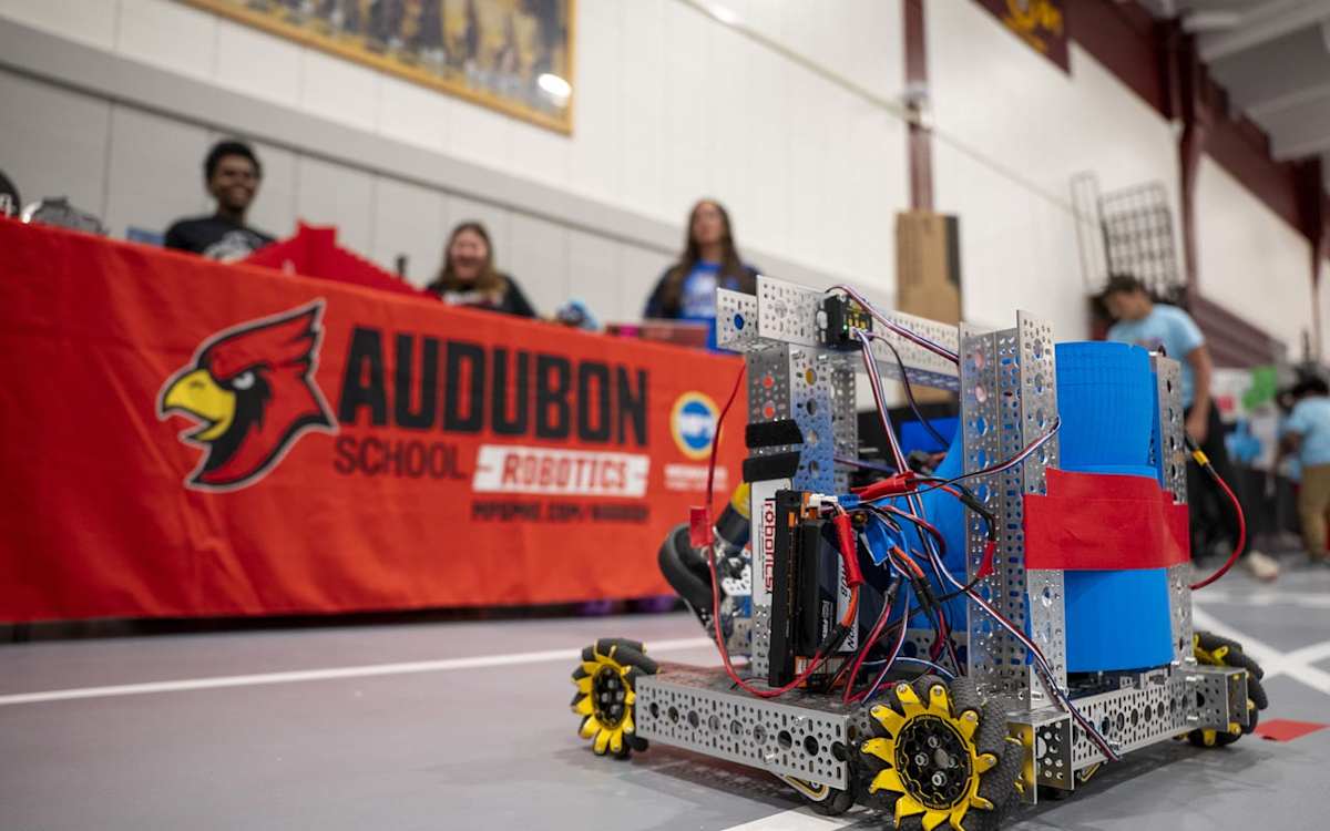 Students from Audubon School's Robotics team look at one of their robotic devices.