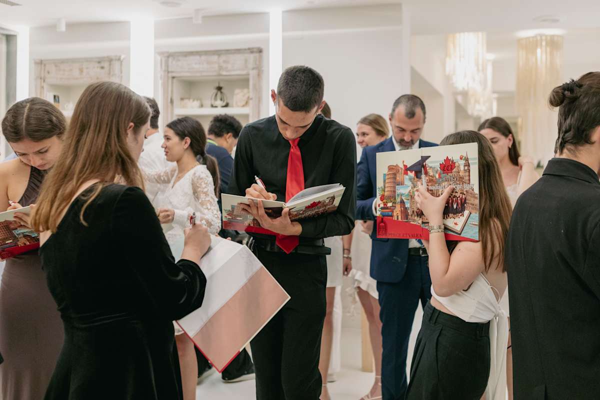 Students gathered around a table signing yearbooks